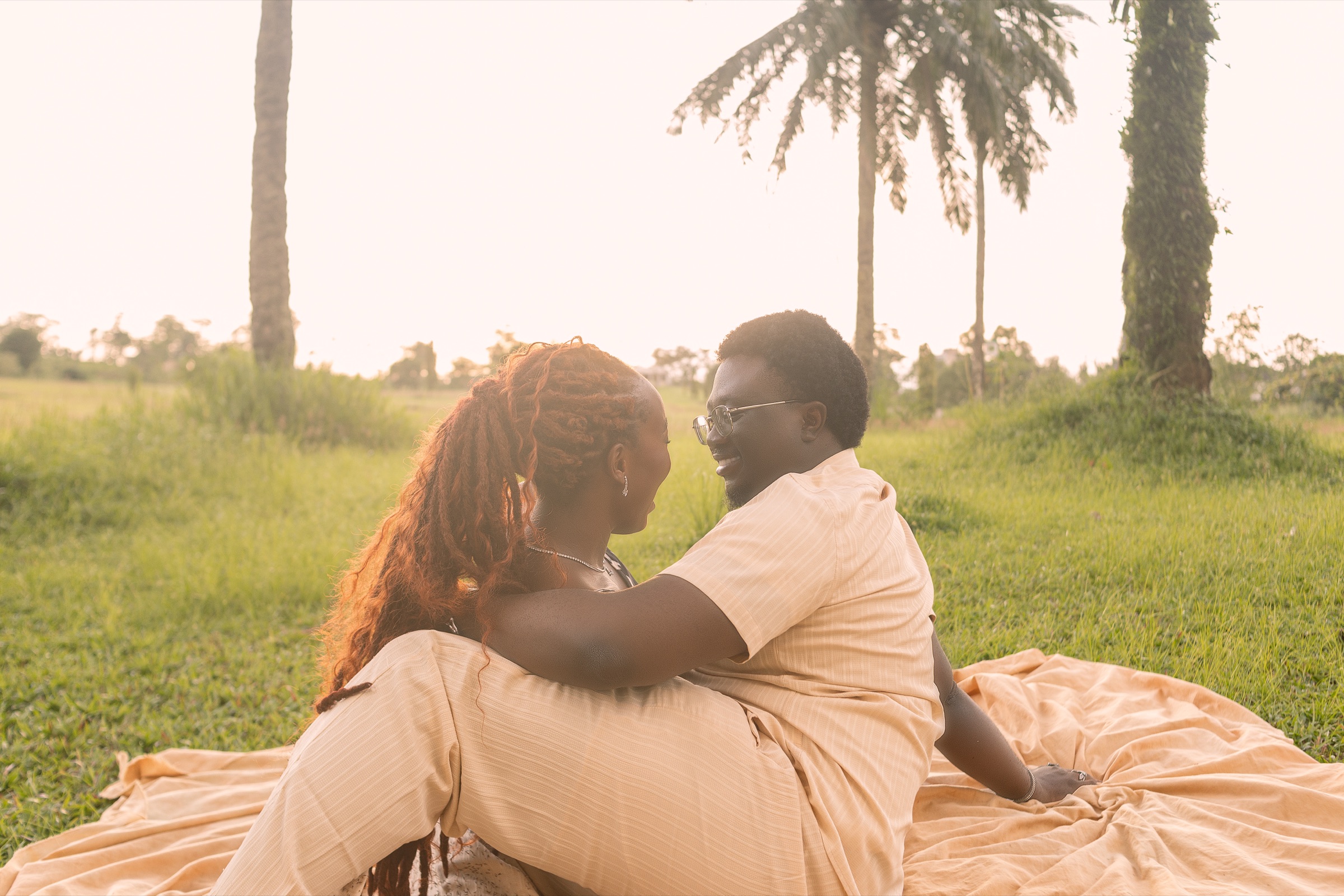 Esther-Praise and Jeremiah seated together in a warm pre-wedding film scene